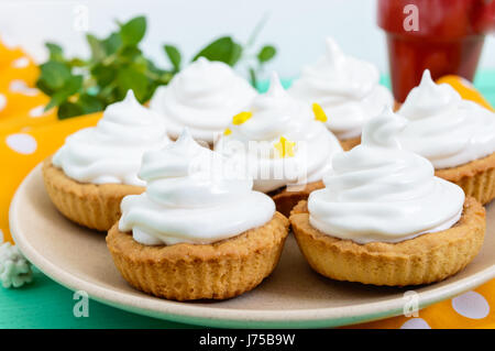 Mini tarte avec une crème d'air sur une assiette et une tasse de café sur un fond de bois. Close up Banque D'Images