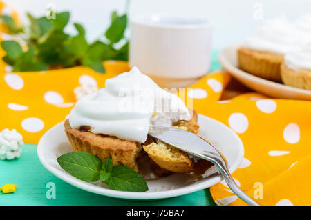 Mini tarte avec une crème d'air sur une assiette et une tasse de café sur un fond de bois. Close up Banque D'Images