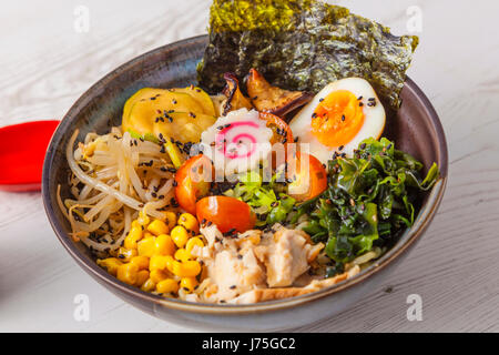 Le miso Ramen nouilles asiatiques avec de la viande et d'oeufs dans un bol blanc sur fond de bois. Banque D'Images