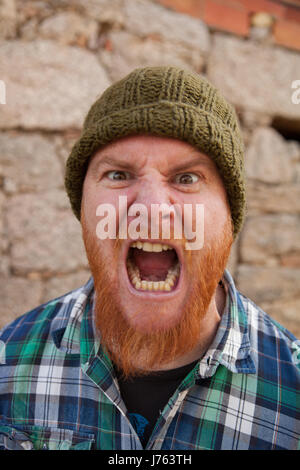 Portrait of a red haired hipster guy mettant face stupide Banque D'Images