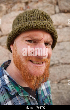 Portrait of a red haired hipster guy mettant face stupide Banque D'Images