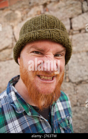 Portrait of a red haired hipster guy mettant face stupide Banque D'Images