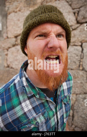 Portrait of a red haired hipster guy mettant face stupide Banque D'Images