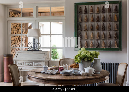 Penguin firgurines affiché dans un cadre vert gras sur le mur de cuisine. Le bureau, la lampe et la table circulaire sont tous par Bardoe & Appel Banque D'Images