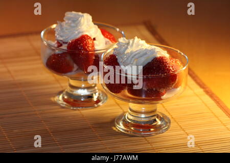 Dans Romanovian fraise style. Fraise est arrosé avec le jus de citron, saupoudré de sucre et décoré avec de la crème fouettée. Banque D'Images