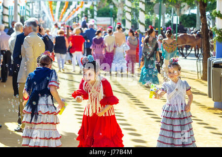 Séville, Espagne - 02 mai 2017 : les petites filles jouant avec des bulles de savon à la foire d'Avril de Séville. Banque D'Images