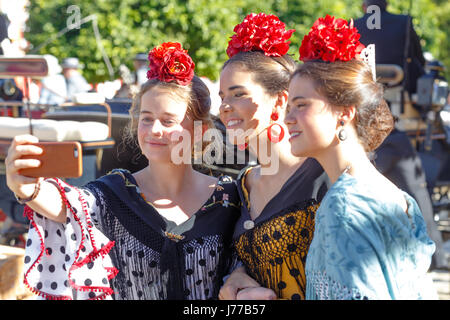 Séville, Espagne - 02 mai 2017 : Trois belles femmes prenant la photo à selfies Foire d'Avril de Séville. Banque D'Images