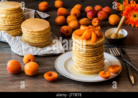 Maison de Stackes crêpes américaines avec du miel et d'abricot sur fond de bois. Banque D'Images