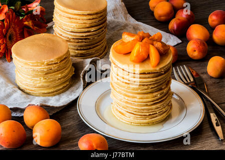 Maison de Stackes crêpes américaines avec du miel et d'abricot sur fond de bois. Banque D'Images