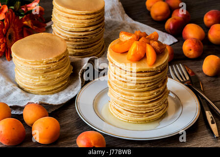 Maison de Stackes crêpes américaines avec du miel et d'abricot sur fond de bois. Banque D'Images