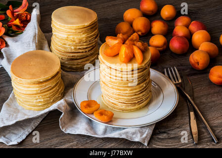 Maison de Stackes crêpes américaines avec du miel et d'abricot sur fond de bois. Banque D'Images