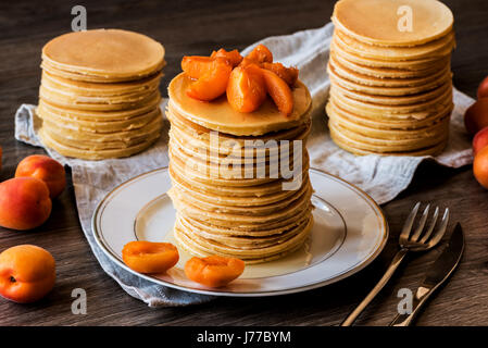 Maison de Stackes crêpes américaines avec du miel et d'abricot sur fond de bois. Banque D'Images