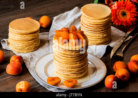 Maison de Stackes crêpes américaines avec du miel et d'abricot sur fond de bois. Banque D'Images