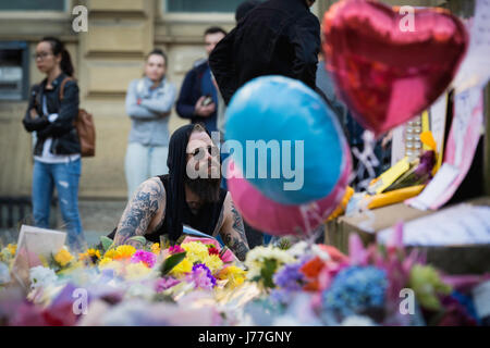 Manchester, UK. 23 mai, 2017. L'homme laisse fleurs à St Anns Square, Manchester après une veillée a eu lieu dans la solidarité après l'attaque de Manchester Arena la nuit d'avant qui a fait 22 blessés et vie 59. Credit : Andy Barton/Alamy Live News Banque D'Images