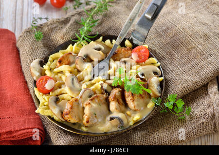 Médaillons de filet de porc frit avec spaetzle Souabe (Schwabenpfandl Schwabentopf ou soi-disant ) et champignons sauce crème servi dans une poêle Banque D'Images