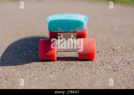 Conseil Blue Penny avec roues rose se dresse sur la piste. Banque D'Images