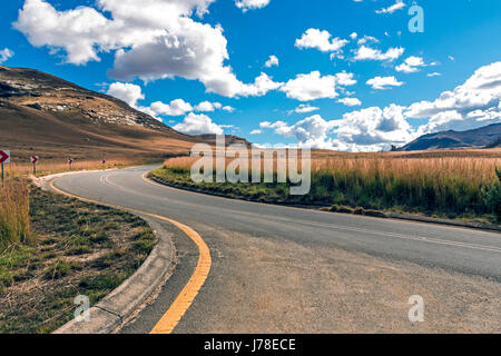 Vide - asphalte rural route qui traverse un paysage de montagne Hiver sec contre ciel nuage bleu horizon n'Etat libre d'Orange en Afrique du Sud