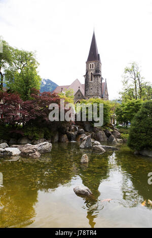 Un jardin Japonais à Interlaken en Suisse. La flèche de l'Église Schlosskirche (Château) se lève dans l'arrière-plan. Banque D'Images