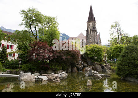 Un jardin Japonais à Interlaken en Suisse. La flèche de l'Église Schlosskirche (Château) se lève dans l'arrière-plan. Banque D'Images