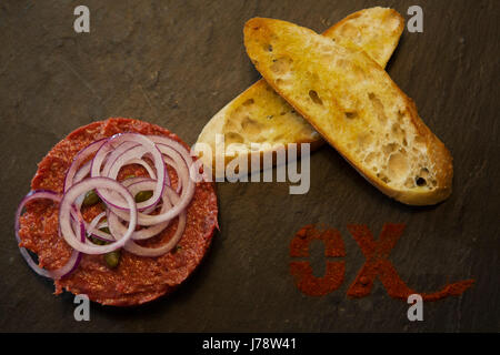 Tartare de boeuf servi servi à Interlaken en Suisse. Le plat est accopanied avec du pain grillé et l'oignon. Banque D'Images