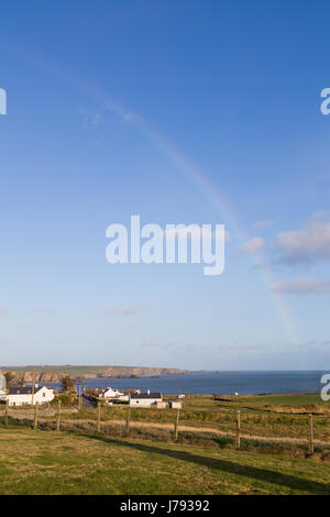 Un arc-en-ciel en milieu rural campagne irlandaise se terminant dans la mer d'Irlande Banque D'Images