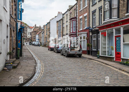 Les gens qui marchent le long des étroites rues pavées de Staithes, North Yorkshire, Royaume-Uni Banque D'Images