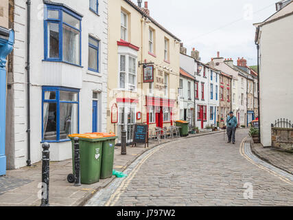 Les gens qui marchent le long des étroites rues pavées de Staithes, North Yorkshire, Royaume-Uni Banque D'Images