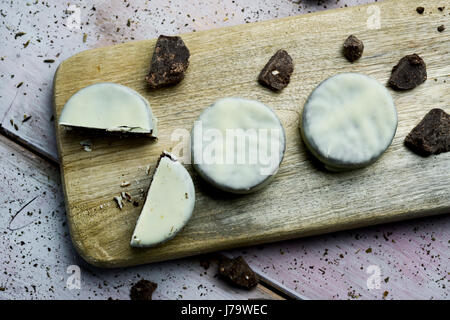 Tourné à angle élevé de certains argentine-uruguayen alfajores rempli de dulce de leche et recouverts d'une couche blanche sur une planche en bois, sur une ru Banque D'Images