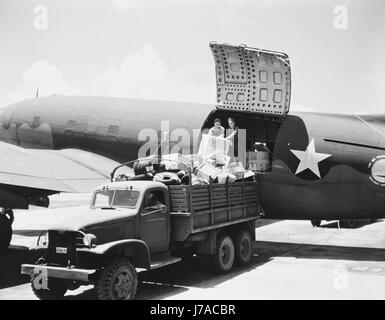 Décharger des cargaisons d'un Air Transport Command de l'armée américaine de cargo, vers 1943. Banque D'Images