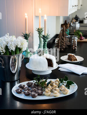 Petites tartes et gâteaux de Noël sur une pierre noire dans l'élégant quartier de plan de cuisine aux chandelles Banque D'Images