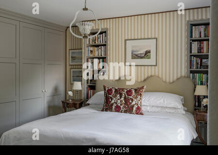 Couper celvet coussin sur lit avec tête de lit linge de maison ancien Serge Claremont. Le tissu rayé les murs sont par Nicole Fabre Banque D'Images