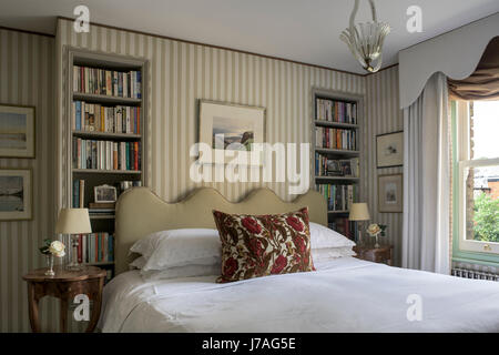 Couper celvet coussin sur lit avec tête de lit linge de maison ancien Serge Claremont. Le tissu rayé les murs sont par Nicole Fabre Banque D'Images