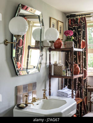 Deux grandes lumières et orb avec rayonnages de bois vintage miroir au-dessus de lavabo Banque D'Images