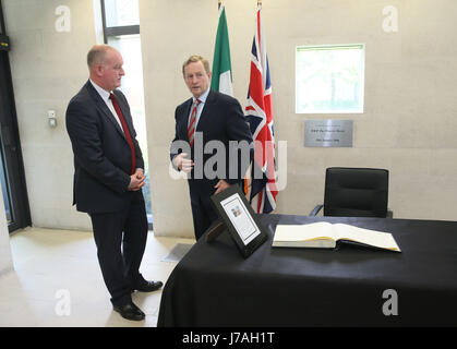 Premier ministre irlandais Enda Kenny, avec Chef de Mission Adjoint Neil Holland (à gauche), après la signature d'un livre de condoléances à l'ambassade britannique à Dublin pour ceux qui sont touchés par l'attaque de Manchester. Banque D'Images