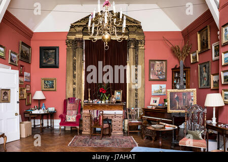 Une grande récupération de 15ème siècle en bois doré et velours by lippi filippino fronton autour de rideau fenêtre dans salle de dessin peint dans le livre de Farrow & Ball Salle Rouge Banque D'Images