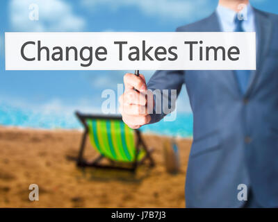 Le changement nécessite du temps - Businessman hand holding sign. Le commerce, la technologie, internet concept. Stock Photo Banque D'Images