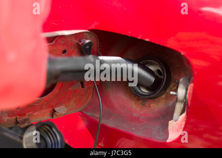 Ajouter du carburant à partir d'une bouteille en plastique pour le réservoir de la voiture. Le remplissage de carburant en plastique d'une bouteille. Panne de voiture. Pas de carburant. L'ajout de carburant. Banque D'Images