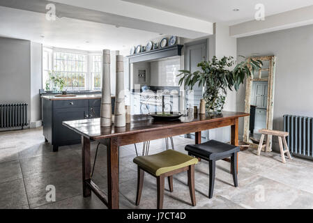 Vintage metal chaises et d'une paire de Philippe Hurel tabourets autour d'une table en bois dans le quartier chic de martin moore cuisine avec cuisinière lacanche et sols en pierre de f Banque D'Images