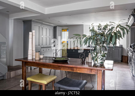 Vintage metal chaises et d'une paire de Philippe Hurel tabourets autour d'une table en bois dans le quartier chic de martin moore cuisine avec cuisinière lacanche et sols en pierre de f Banque D'Images