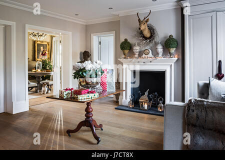 Thym faux cheminée dans le hall spacieux avec des cadeaux de Noël sur la table Banque D'Images