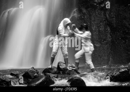 Les filles musulmanes à Tretes cascade en Indonésie une cascade puissante qui ressemble tout à fait calme en utilisant une technique d'exposition longue en noir et blanc Banque D'Images