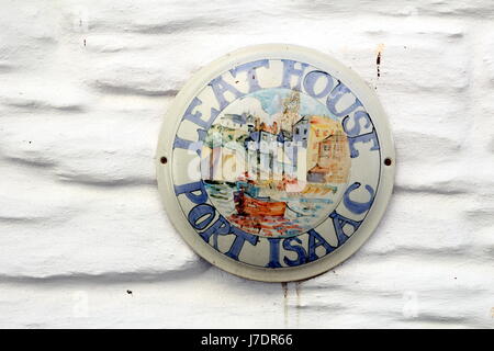 Plaque nom de maison, disant "Leat Maison Port Isaac', sur un mur de brique peint en blanc Banque D'Images