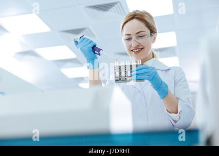 Jeune femme travaillant positif laboratoire chimique Banque D'Images