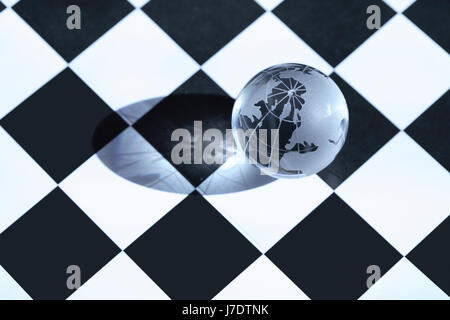 Concept d'échecs. Globe en verre transparent couché sur échiquier Banque D'Images
