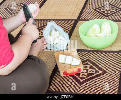 Jeune femme au foyer est tranchant les courges fraîches sur l'Armure pour le temps de préparation du dîner. Banque D'Images