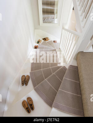 Meubles pour chaussures sur escalier peint avec Roger Oates stair runner. L'escalier et bannister sont peints dans des biens immobiliers par pointage Farrow & Ball Banque D'Images