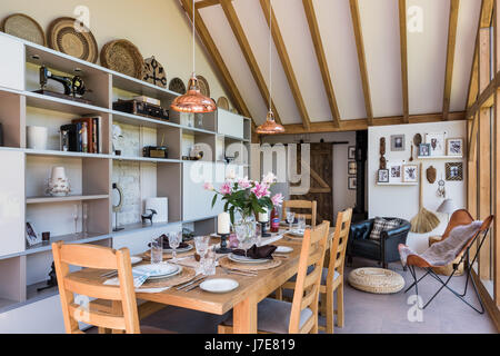 Chêne-pans voûtée, salle à manger avec de grandes baies vitrées. La table et les chaises sont de John Lewis et le coolicon insustrial pendentif cuivre ligh Banque D'Images