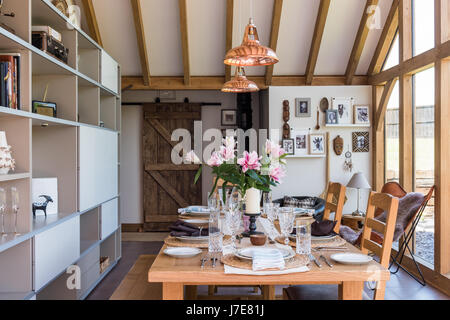 Chêne-pans voûtée, salle à manger avec de grandes baies vitrées. La table et les chaises sont de John Lewis et le coolicon insustrial pendentif cuivre ligh Banque D'Images