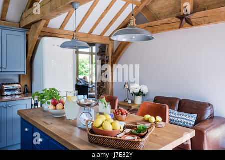 L'unité de l'île lumineuse peinte en bleu par Stiffkey Farrow & Ball en chêne avec cuisine à pans suspendus Banque D'Images