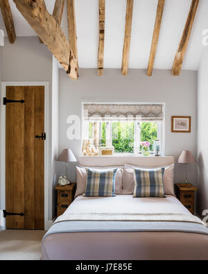 Chambre confortable avec des poutres apparentes et meubles de chevet à partir de planches étroites meubles Indigo. Banque D'Images